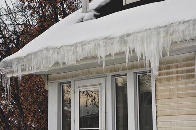 A roof with a large ice dam over the gutters