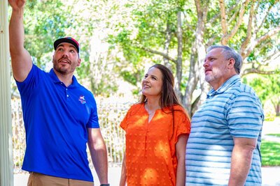 A Mighty Dog Roofing emergency roofer inspecting a roof with his customers
