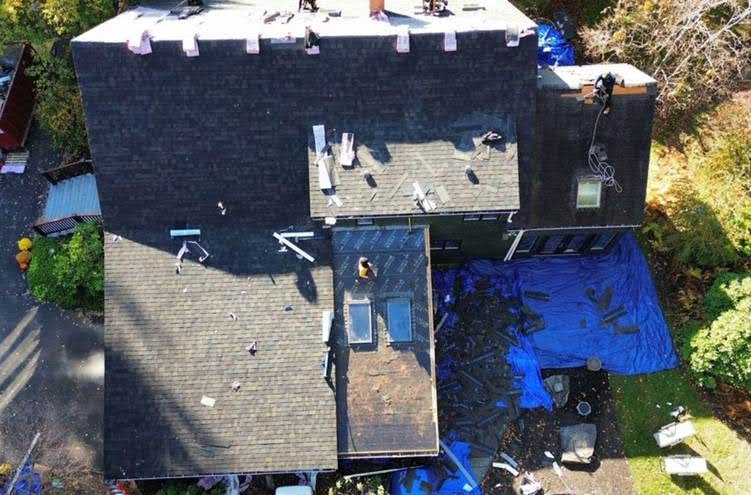 Team from a roofing company in Tewksbury, MA, performing detailed roof installation, highlighting expert local service.